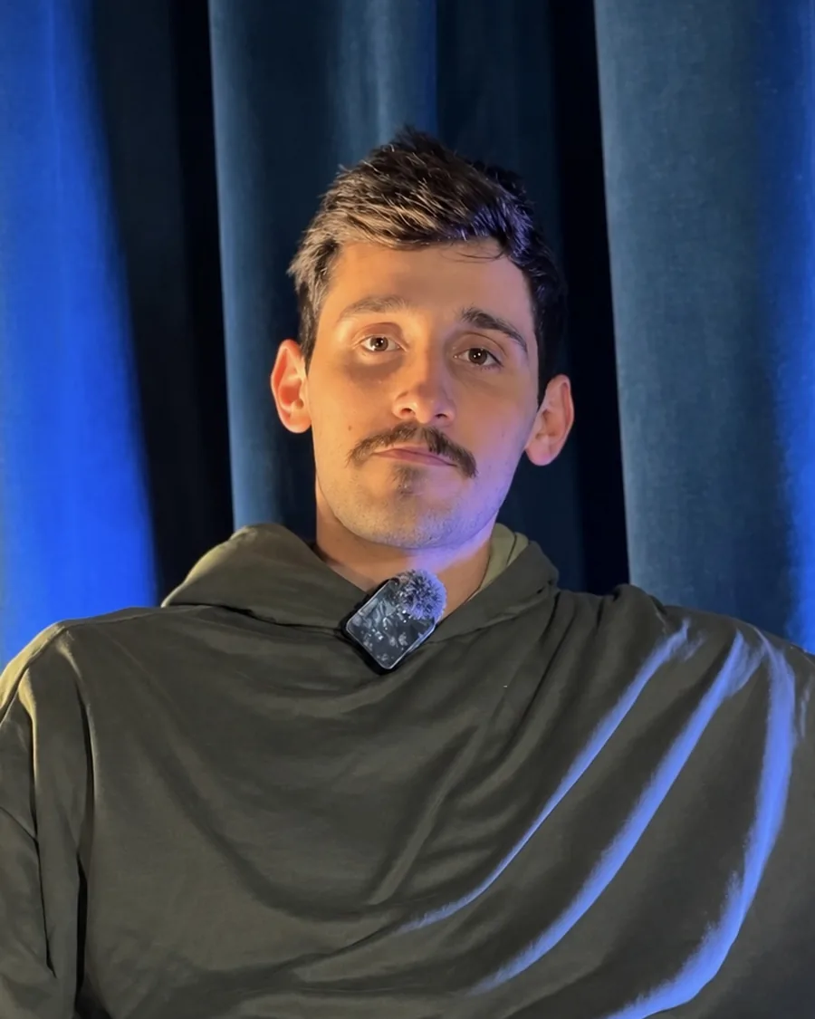 Retrato de Julián Barreiro, Dirección de Marketing e IA de NEXO Studios, con buzo verde y micrófono de solapa
